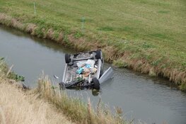 Auto op de kop in sloot Sint Maarten, bestuurder ongedeerd