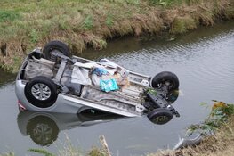 Auto op de kop in sloot Sint Maarten, bestuurder ongedeerd