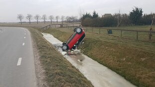 Auto van de weg op het ijs op zijn dak